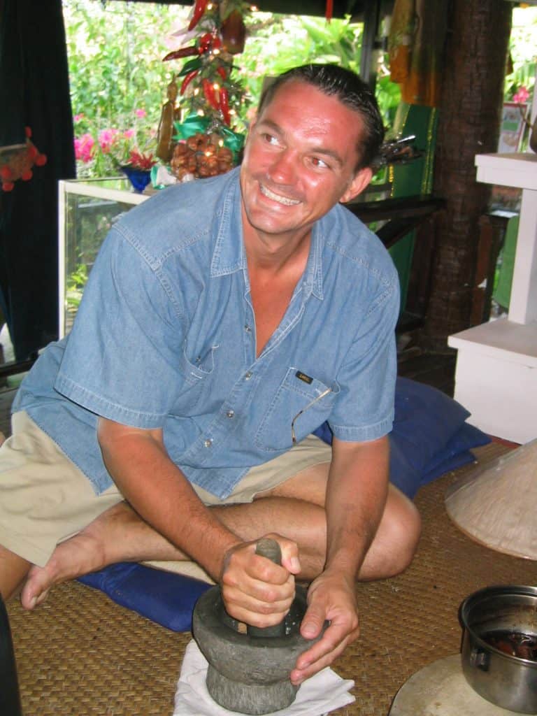 man mixing herbs to make common thai curries