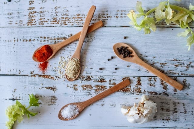 Assortment Of Colorful Spices In The Wooden Spoons On The White