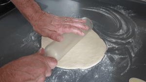 rolling out pizza dough