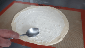 divide ricotta on pizza crust