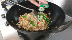 adding pepper to fried rice