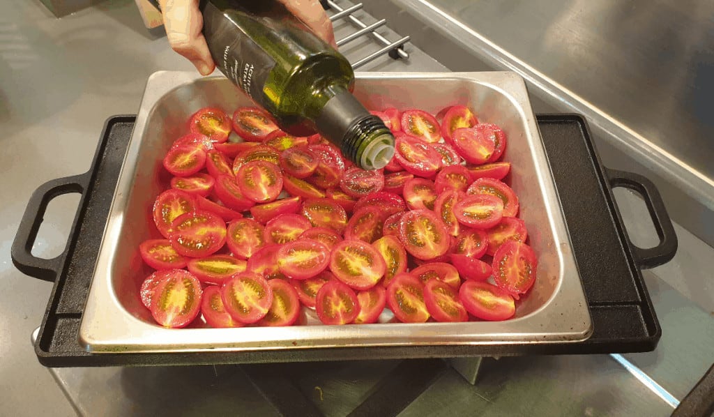 pouring olive oil over tomato confit