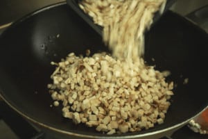 adding diced mushrooms in a wok