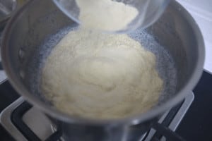 adding semolina powder in hot milk