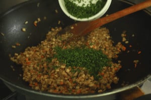adding parsley to stir fried mushrooms