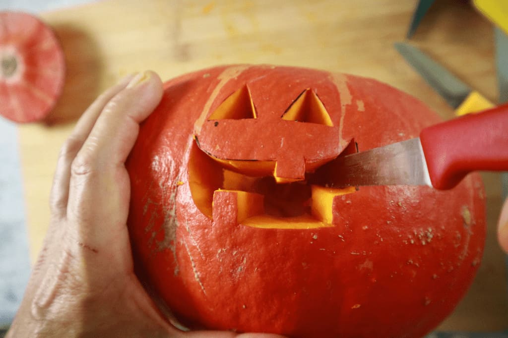 cutting a scary face in a pumpkin for halloween