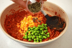 mixing vegetables in a bolognaise sauce