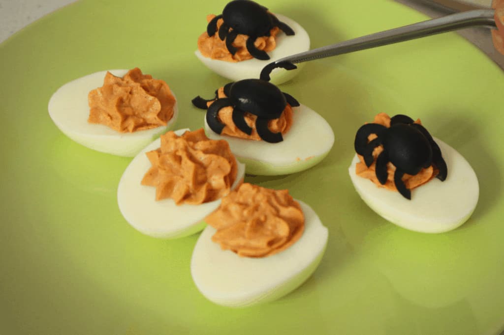 decorating the devilled eggs with olive spiders