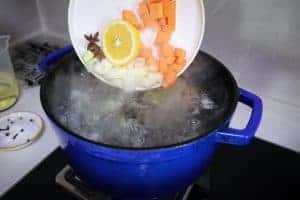 adding aromatic vegetables to boiling water