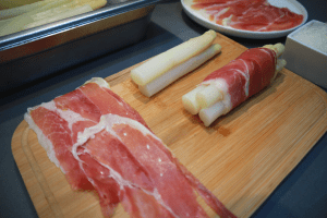 wrapping white asparagus in ham