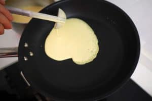 pouring batter to make crepes