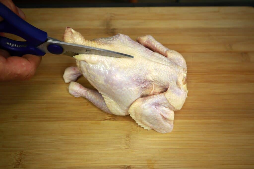 cutting the back of the chicken