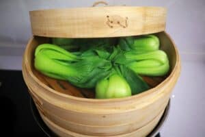 steaming pak choi in bamboo basket